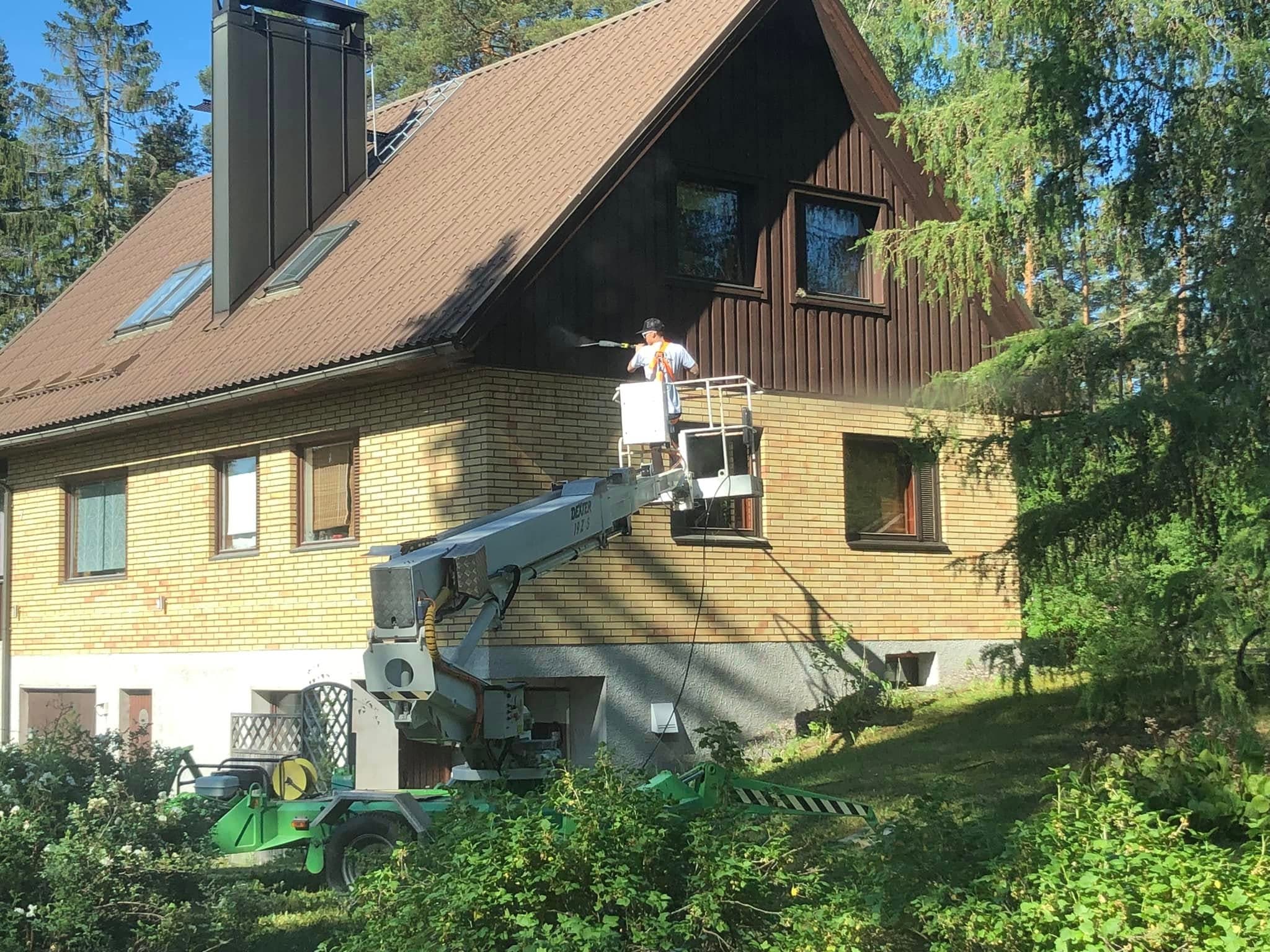 Puutalon julkisivun huoltomaalausta tehdään henkilönostimelta